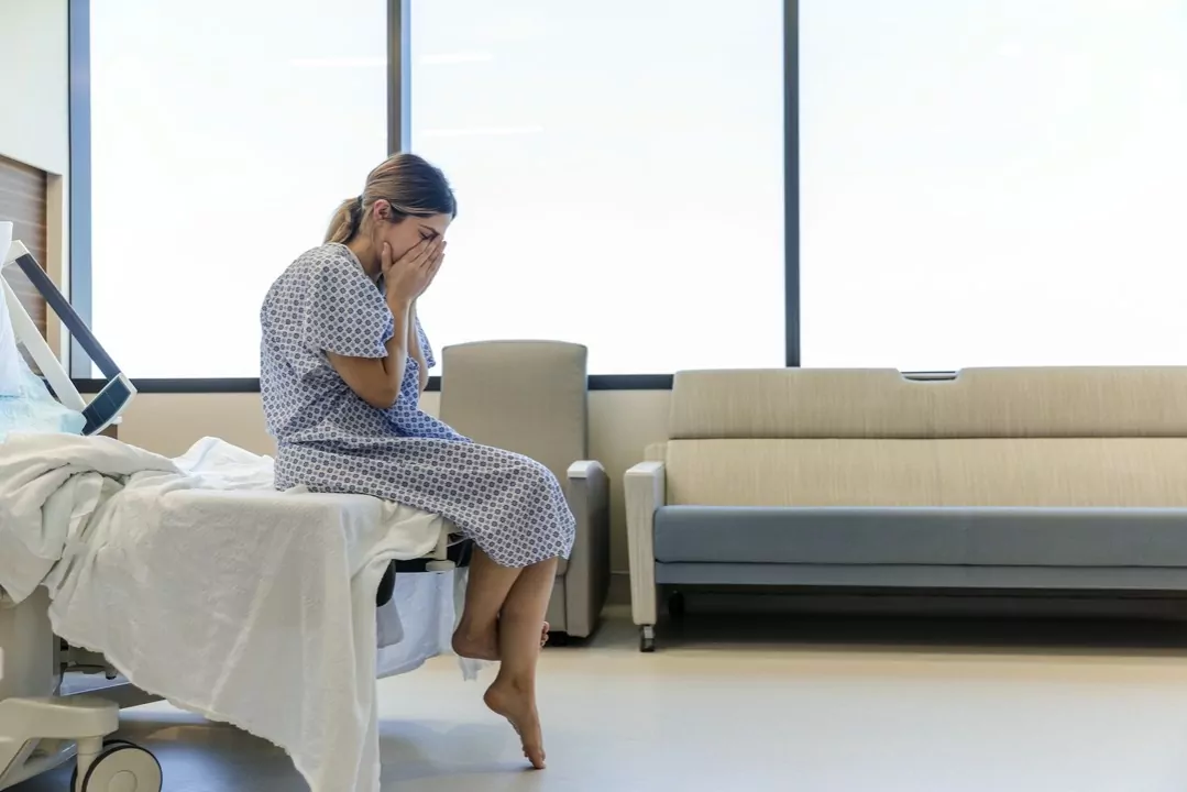 płacząca kobieta na łóżku szpitalnym
